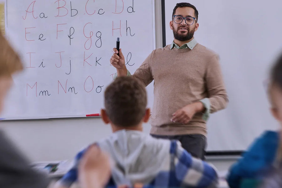insegnante scuola primaria con bambini che imparano a scrivere